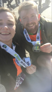 man and woman with half marathon medals