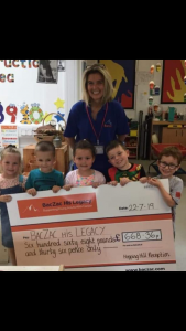 woman and children holding giant cheque